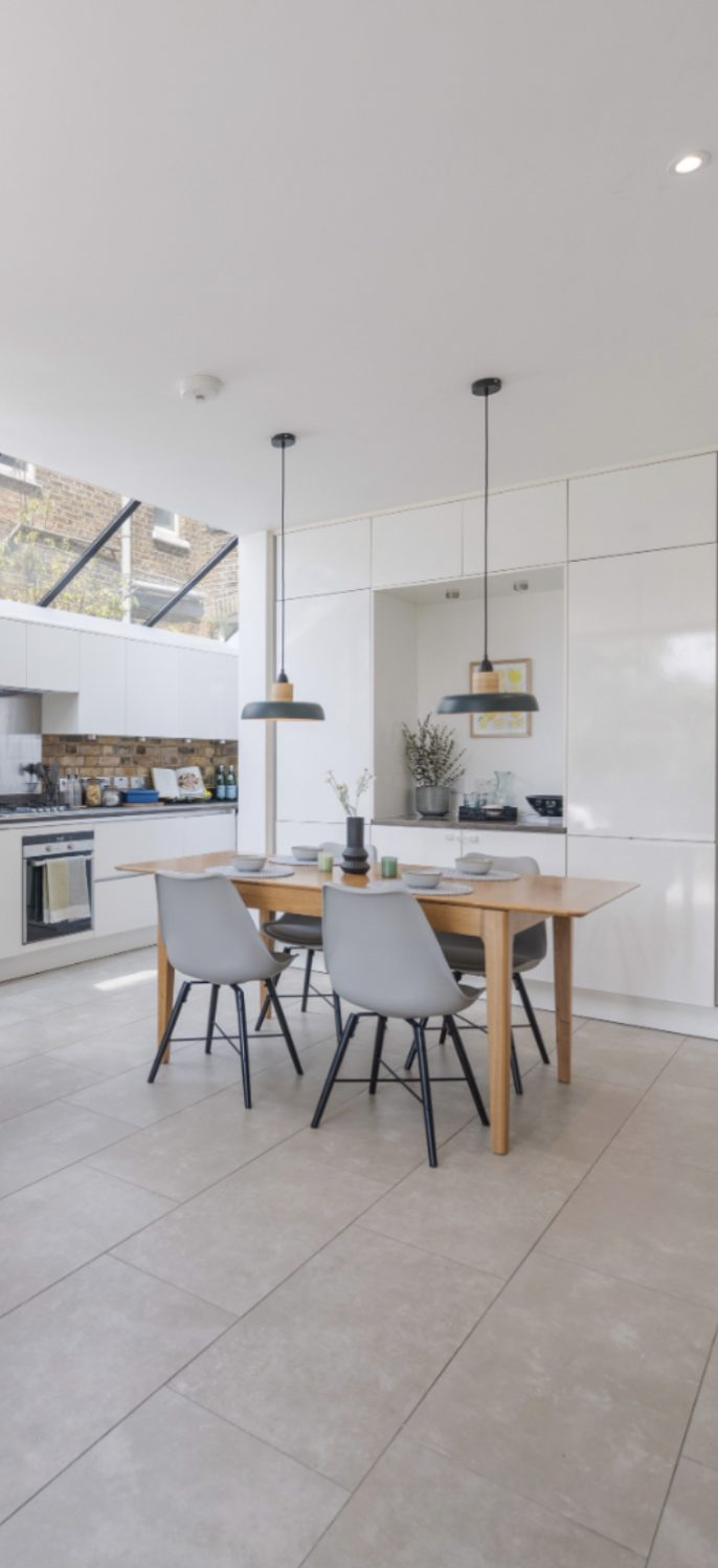 Bright open-plan kitchen and dining space in a new home, furnished and styled