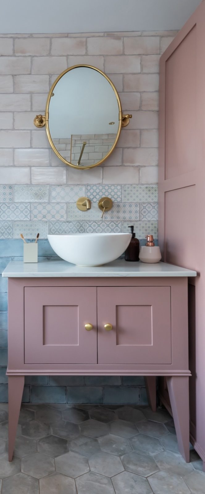 Pink vanity unit with brass fittings in a styled bathroom, home restyling