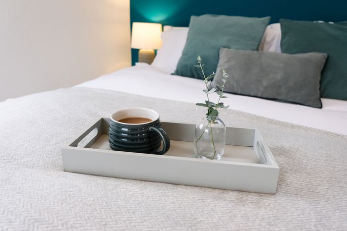 Same space staged with a blue sofa and wooden dining table