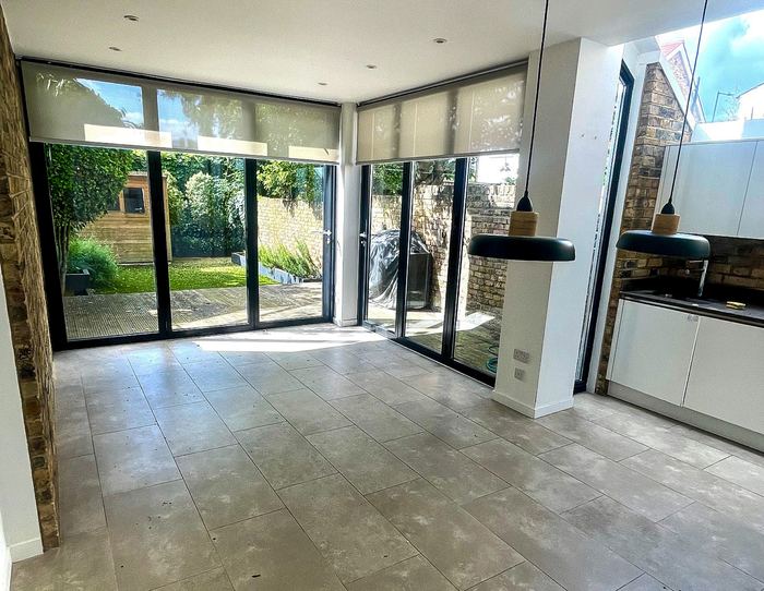 Empty kitchen and dining extension with skylights and bifold doors, before styling