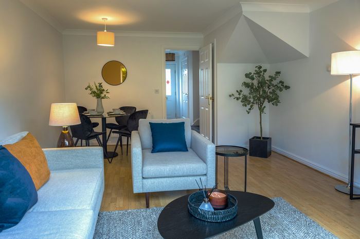 Living and dining room staged with grey and blue seating