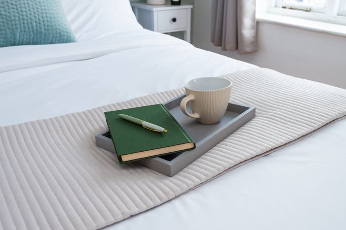 Bed tray styled with a notebook, pen and mug