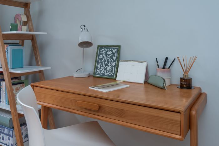Desk vignette styled with a lamp, framed art and calendar