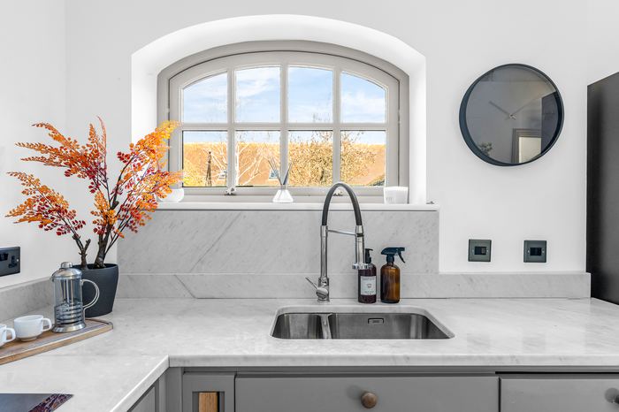 Kitchen counter styled beneath an arched window