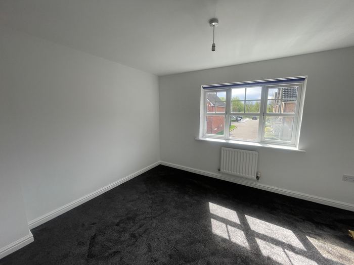 Empty bedroom with dark carpet, before styling