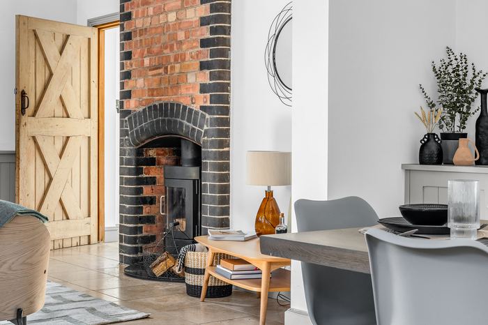Living room detail with a wood-burning stove and brick chimney breast