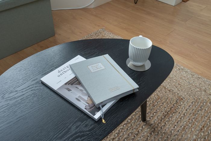 Coffee table detail styled with books, a journal and mug