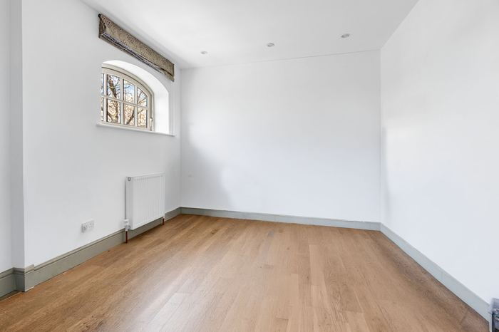 Empty bedroom with an arched window, before styling